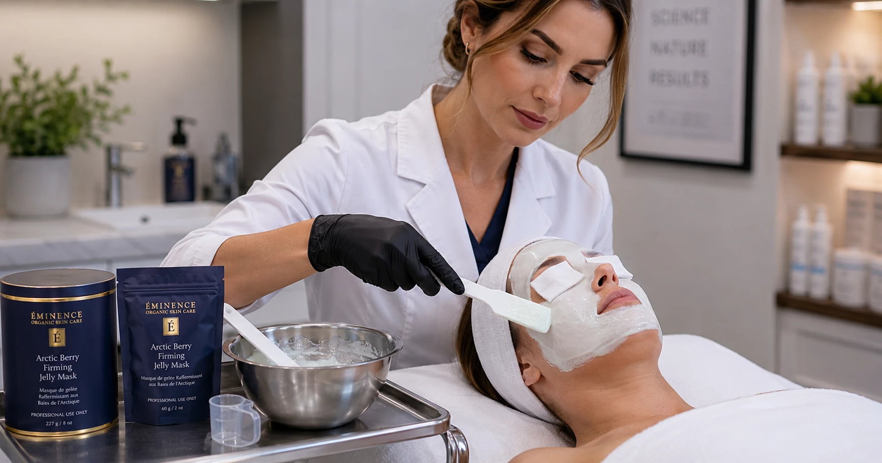 Esthetician applying a professional jelly mask with careful attention to the periorbital and perioral zones on a client in a clinical treatment room